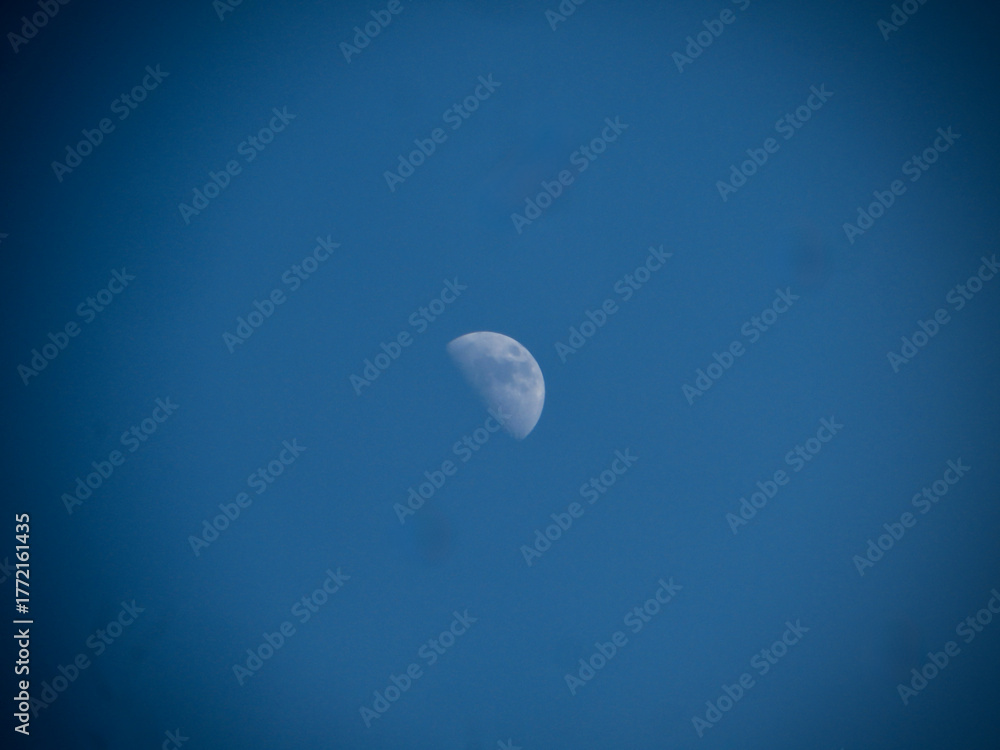 Fototapeta premium Crescent Moon Against Clear Blue Sky - Daytime Lunar Photography Stock Image on West Lake in Hanoi, Vietnam