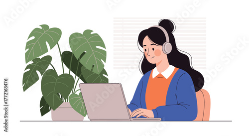 A smiling young woman in headphones diligently works on her laptop at a clean desk, enjoying a serene indoor plant setting.