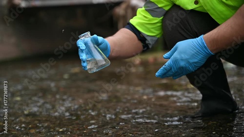 An environmental expert is collecting water samples from a stream to test its pH and monitor its ecosystem in a science lab.
