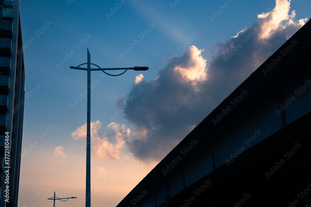 Obraz premium Urban streetlight silhouette against dramatic sunset sky