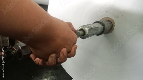 ​Worker Adjusting Core Shaft on Industrial Paper Roll Winding Machine