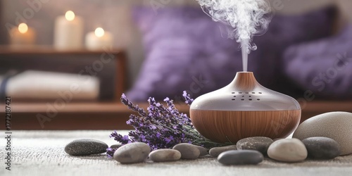 A diffuser emitting steam with lavender flowers and rocks in the foreground, with a blurred background featuring a bed and candles.