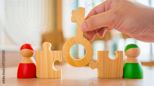Wooden key piece connecting puzzle blocks between two toy figures in red and green, symbolizing communication, teamwork, problem solving, collaboration, and strategic partnership.