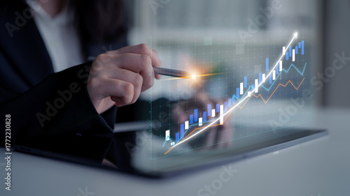 Fotografie A professional individual analyzes data on a tablet, showcasing digital graphs and charts that represent growth and financial performance in a modern workspace