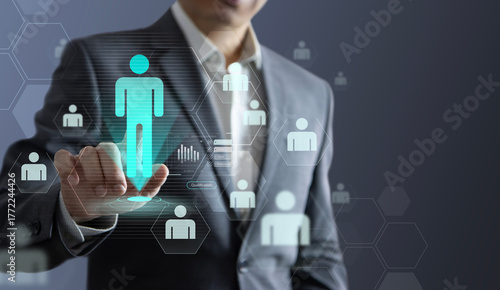 Business administrator interacts with a virtual screen to select the most suitable candidate, symbolizing the integration of manpower management and human resource planning.