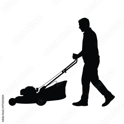 Silhouette of a man mowing a lawn with a push mower