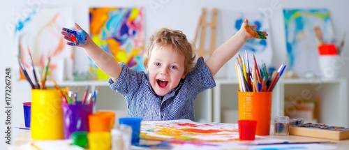 A happy youngster with down syndrome is surrounded by art tools, holding a vibrant painting, and enjoying uniqueness and creativity.