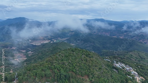 Green mountain valley landscape in Kunming,Mountains and clouds in Kunming, Yunnan,Natural mountain scenery in Kunming,Kunming valley surrounded by green hills,Misty mountain forest in Kunming