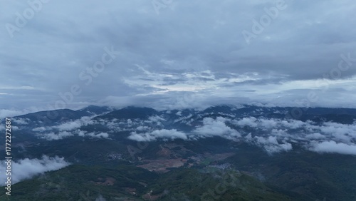 Green mountain valley landscape in Kunming,Mountains and clouds in Kunming, Yunnan,Natural mountain scenery in Kunming,Kunming valley surrounded by green hills,Misty mountain forest in Kunming
