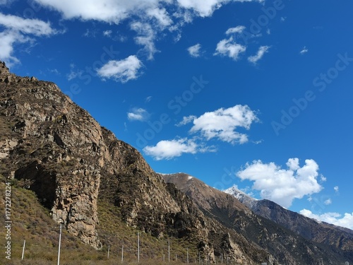 Tibetan plateau village under snowy mountains,Snow-capped mountains, blue sky and Tibetan houses