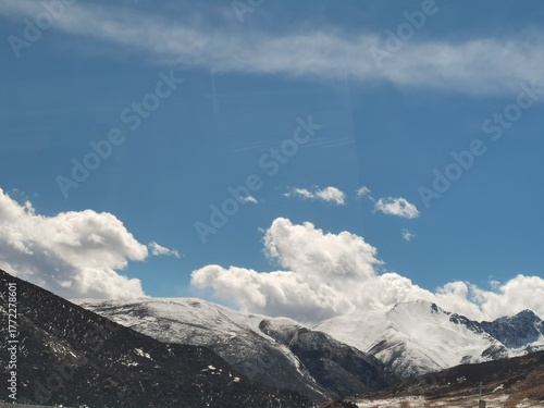 Plateau grassland and snow mountain scenery,Snowy peaks on the plateau under blue sky and white clouds,Natural landscape of the Tibetan Plateau,Golden grassland and distant snow-capped mountains