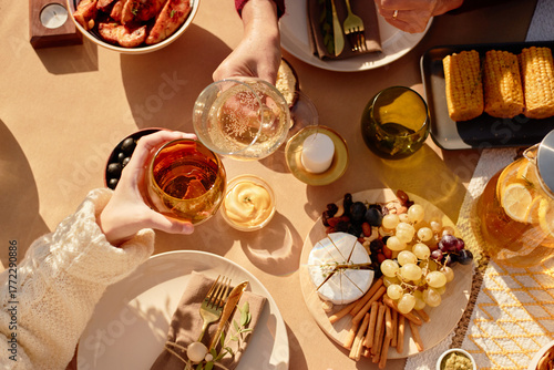 Fotografie Senior woman and girl toasting with glasses over festive table setting, sharing