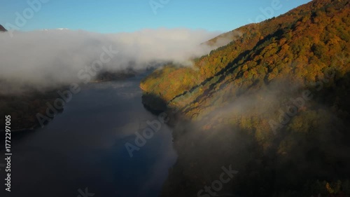 霧の晴れ間から現れる美しい紅葉は新潟県魚沼市の奥只見湖