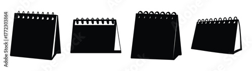 Collection of four spiral bound desk calendars standing on white surface