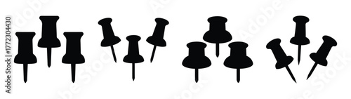 A collection of black push pins scattered on a