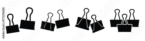 A collection of black binder clips scattered on a
