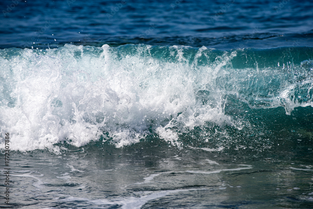 Fototapeta premium Day light on moving sea waves background. Ocean waves break and sparkle in sunlight. Blue sea waves shimmer in summer brightness. Waves splash. Sea wave an ocean texture.