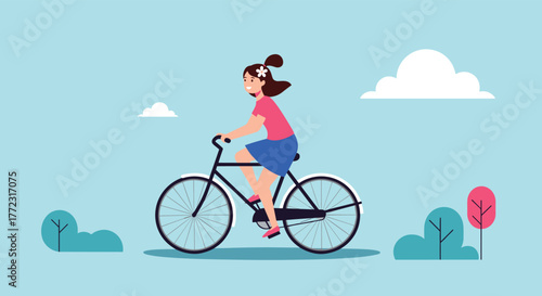 A happy young woman enjoys a leisurely bike ride outdoors under a clear blue sky, embracing an active and healthy lifestyle.