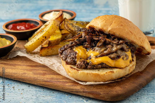 Smash burger with cheddar cheese and caramelized onions, served with fries