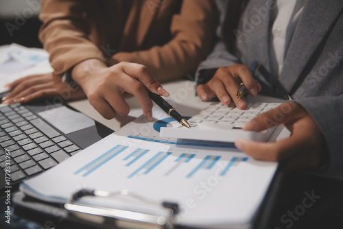 Fotografija Close up Business woman using calculator and laptop for do math finance on woode
