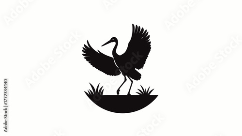 Elegant black silhouette of a crane or stork bird with outstretched wings, standing on natural grass. Minimalist vector illustration icon design.