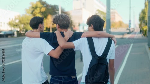 Teenage boys walking together with arms around shoulders in urban street vibe