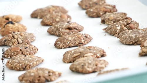 Close-up shot of freshly baked organic brown rice cookies cooling on a rack. Made from Thai organic rice and grains, representing healthy snack production and sustainable agriculture. Perfect for heal