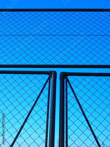 野球場の金網と冬の朝の青空