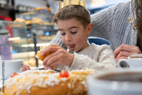 Boy king enjoying roscón de reyes cake during epiphany celebration