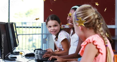 Fototapeta Typing three girls in pastel coral tops at school computer lab with keyboards, with floating stars