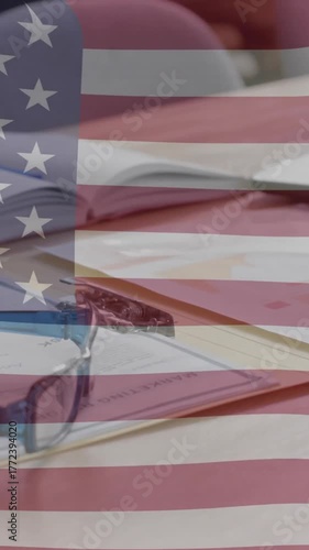 American flag animation over office desk with documents, glasses, and laptop