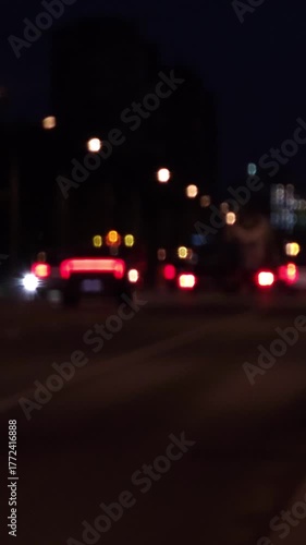Defocused night traffic scene with moving car lights on an urban road, creating soft bokeh atmosphere suitable for backgrounds, transitions and cinematic footage