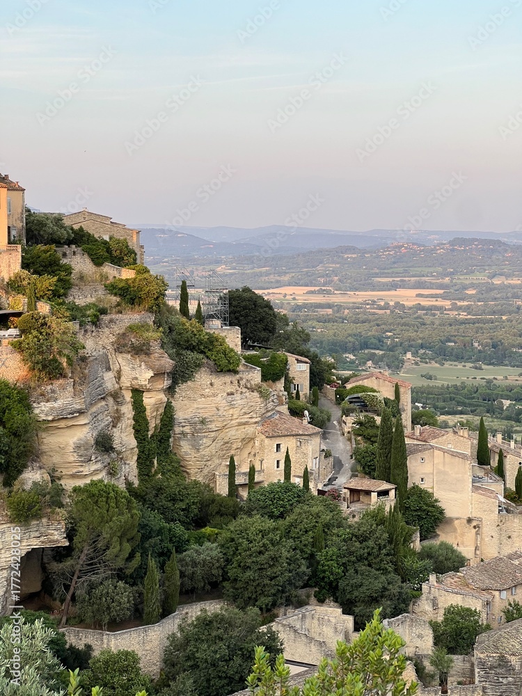 Obraz premium Ancient stone houses built on a rocky cliff surrounded by greenery and valley views