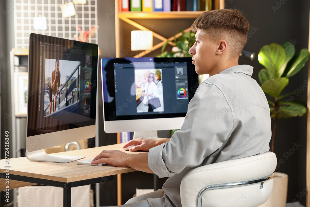 Fototapeta premium Professional retoucher editing photo on computer at table in office