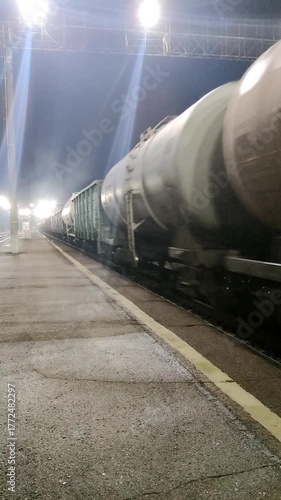 A freight train rushes through the night under bright, glowing lanterns. Sound inside.
