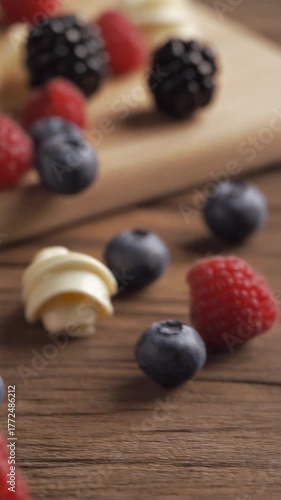 Wallpaper Mural Slow motion footage of fresh raspberries and blueberries rolling on wooden table close up Torontodigital.ca