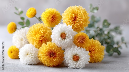Assorted Yellow And White Chrysanthemums With Green Eucalyptus Leaves On A Light Gray Background With Soft Natural Light