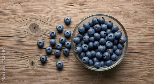 Fresh organic blueberries in a wooden bowl and on a spoon, showcasing ripe, sweet fruit for a healthy dessert