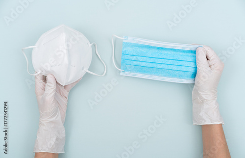 Holding two disposable medical masks and making a choice