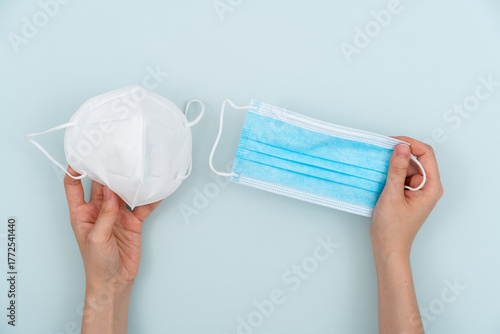 Holding two disposable medical masks and making a choice