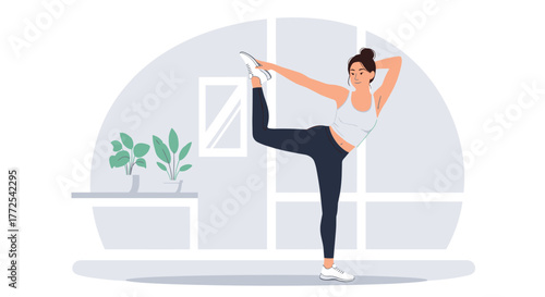 Graceful woman practices yoga dancer pose in bright modern studio promoting wellness and flexibility