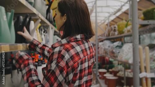 Woman shopping for gardening supplies in a home improvement store during daylight hours