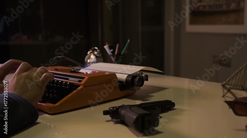 Writer Working on a Crime Script with Typewriter and Gun on the Desk
