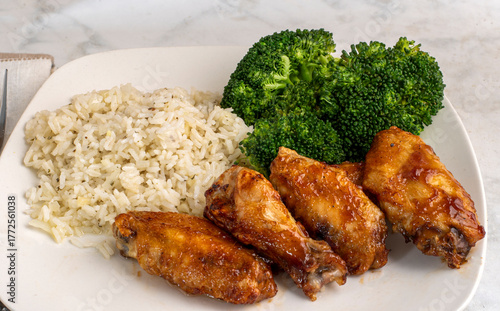 chicken wimgs  and drumsticks with rice and broccoli