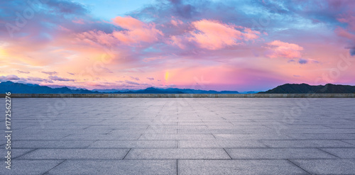 Fototapeta Naklejka Na Ścianę i Meble -  Empty square floor and mountain with dramatic sky clouds landscape at sunset