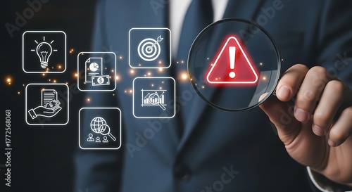 Businessman examining potential risks with magnifying glass and financial icons concept