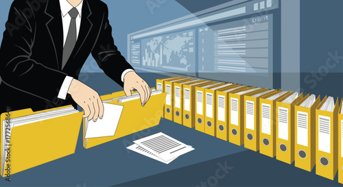 Organized professional filing documents into bright yellow binders in modern office setting with data dashboard