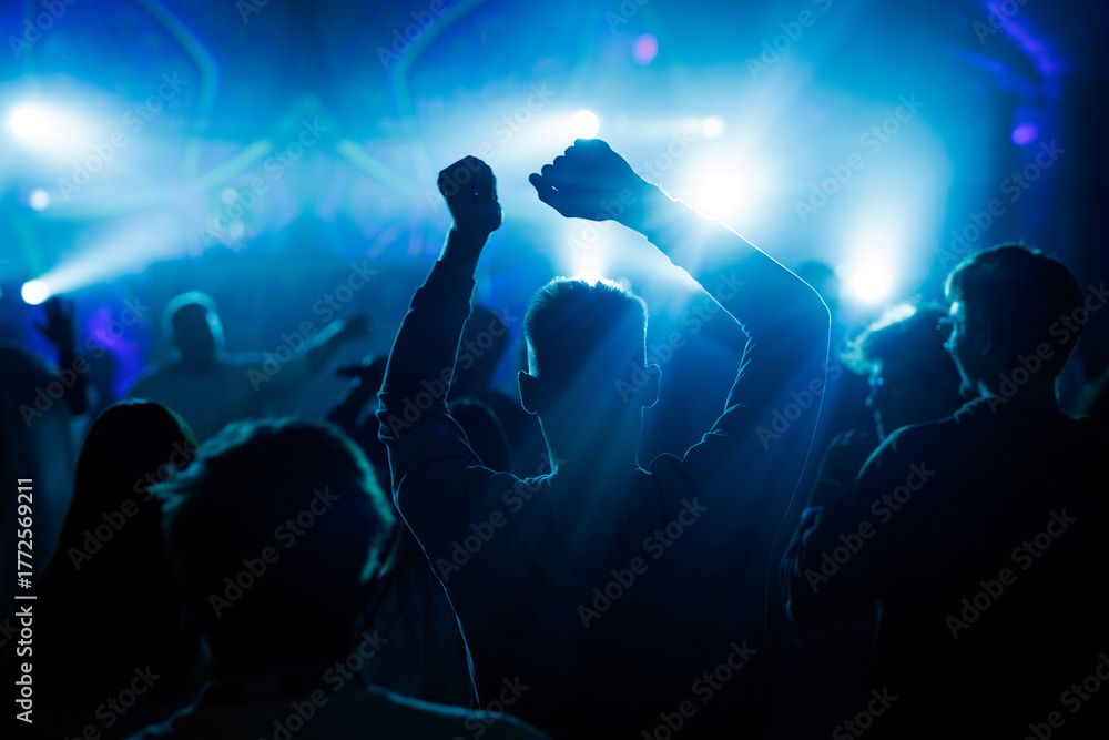 Obraz premium People dancing at concert with blue lights