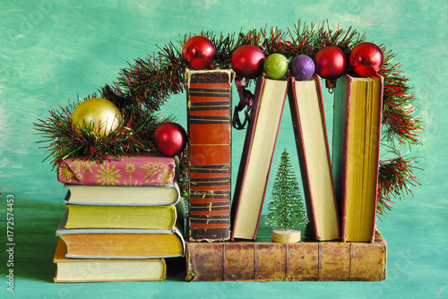 books as christmas gift,christmas present,reading,literature,education, christmas,holiday concept with row of books, christmas tree and decoration