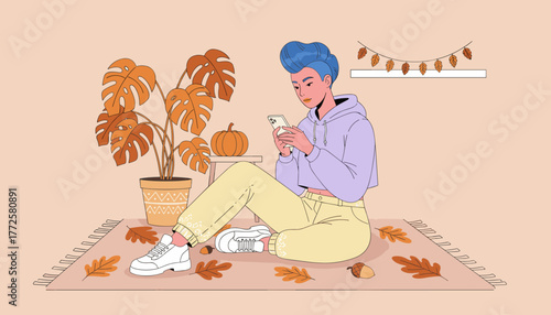Stylish youth relaxes at home using a phone surrounded by modern fall decorations